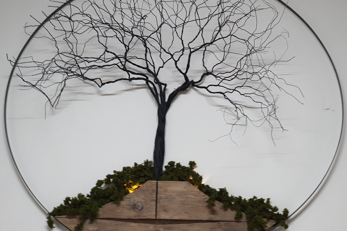 Wire tree-of-life sculpture on reclaimed timber, the emblem of Branch Wellness Clinic